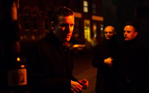Tour guide leading Jack The Ripper & Haunted London Tour at night.