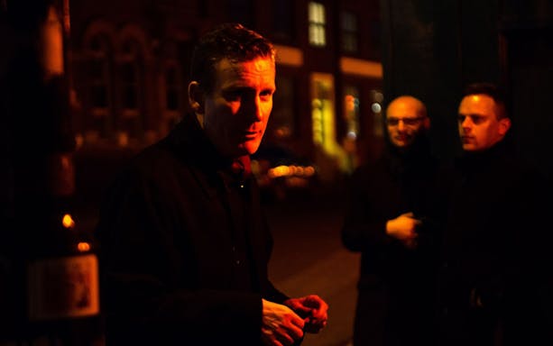 Tour guide leading Jack The Ripper & Haunted London Tour at night.
