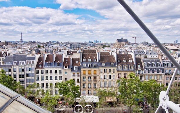 View of Paris rooftops from Centre Pompidou with Eiffel Tower in the distance.