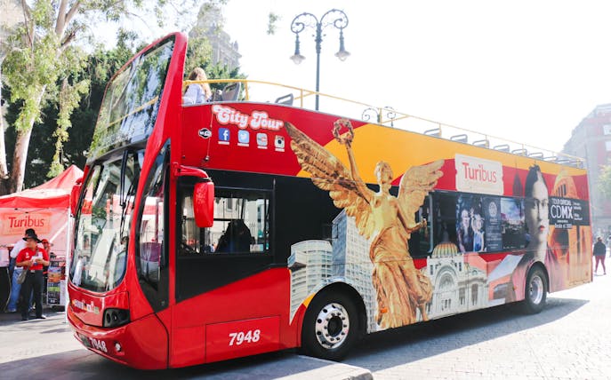 Red double-decker Turibus for Hop On Hop Off Mexico City Tour with iconic city landmarks.