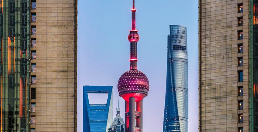 Oriental Pearl TV Tower in Shanghai skyline at dusk.