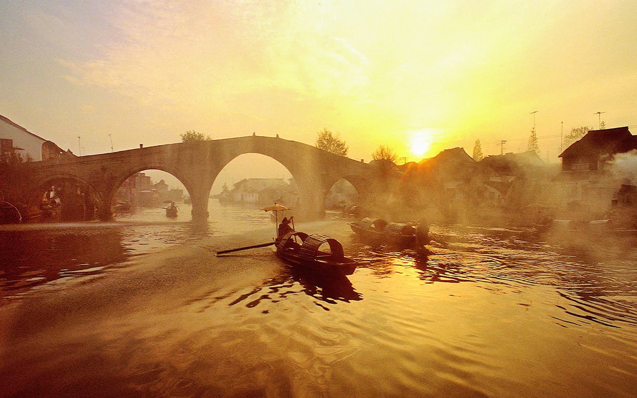 Boats on a canal at sunset in Zhujiajiao Ancient Water Town, China.