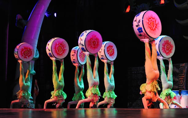 Acrobats balancing drums on their feet at Beijing Chaoyang Theatre show.