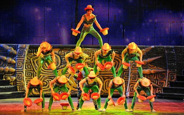 Acrobats performing a balancing act with hats at Beijing Chaoyang Theatre.