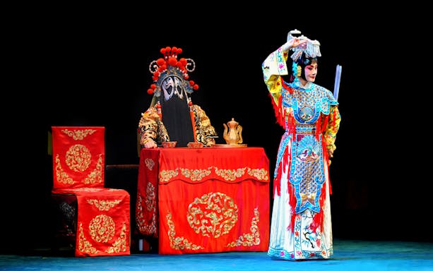 Peking Opera performers in traditional costumes at Beijing Liyuan Theatre.