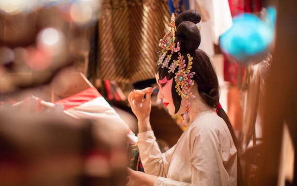 Performer applying makeup for Peking Opera at Beijing Liyuan Theatre.