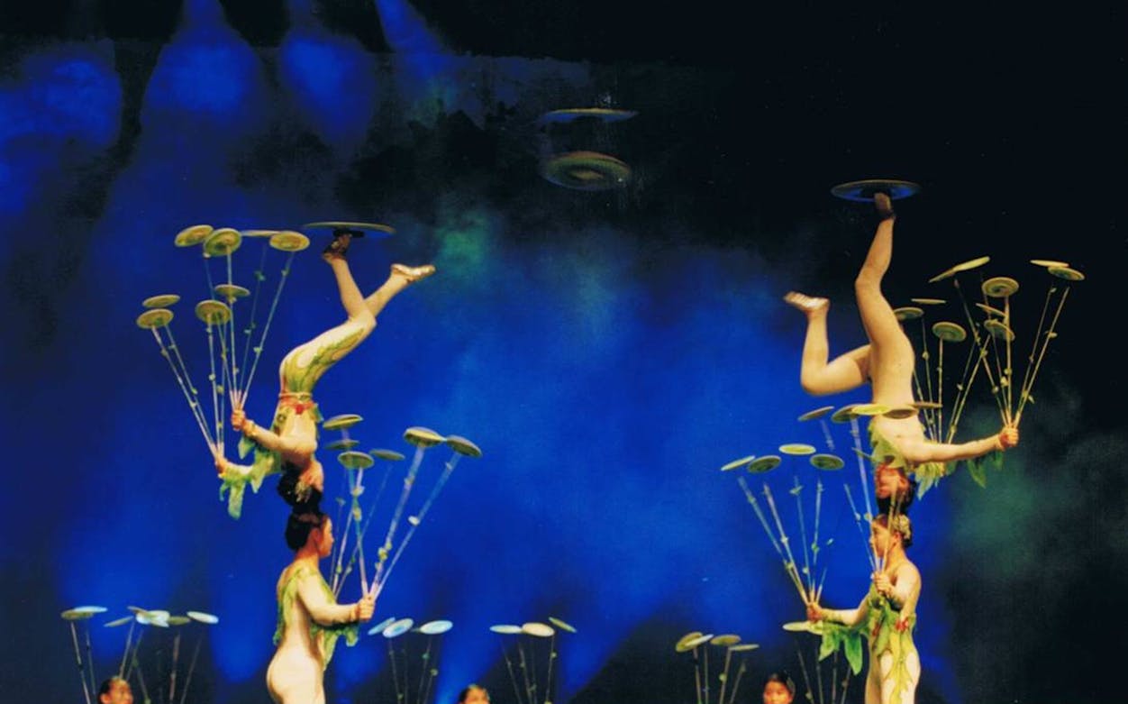 Acrobats balancing plates during Shanghai Acrobatic Troupe performance.