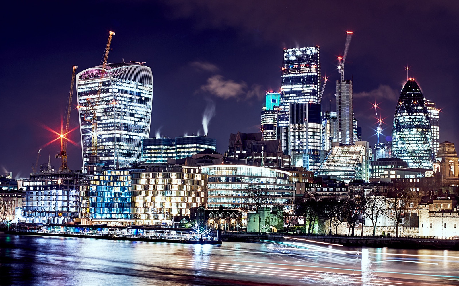 London skyline at night with illuminated skyscrapers and the River Thames, near the lastminute.com London Eye.