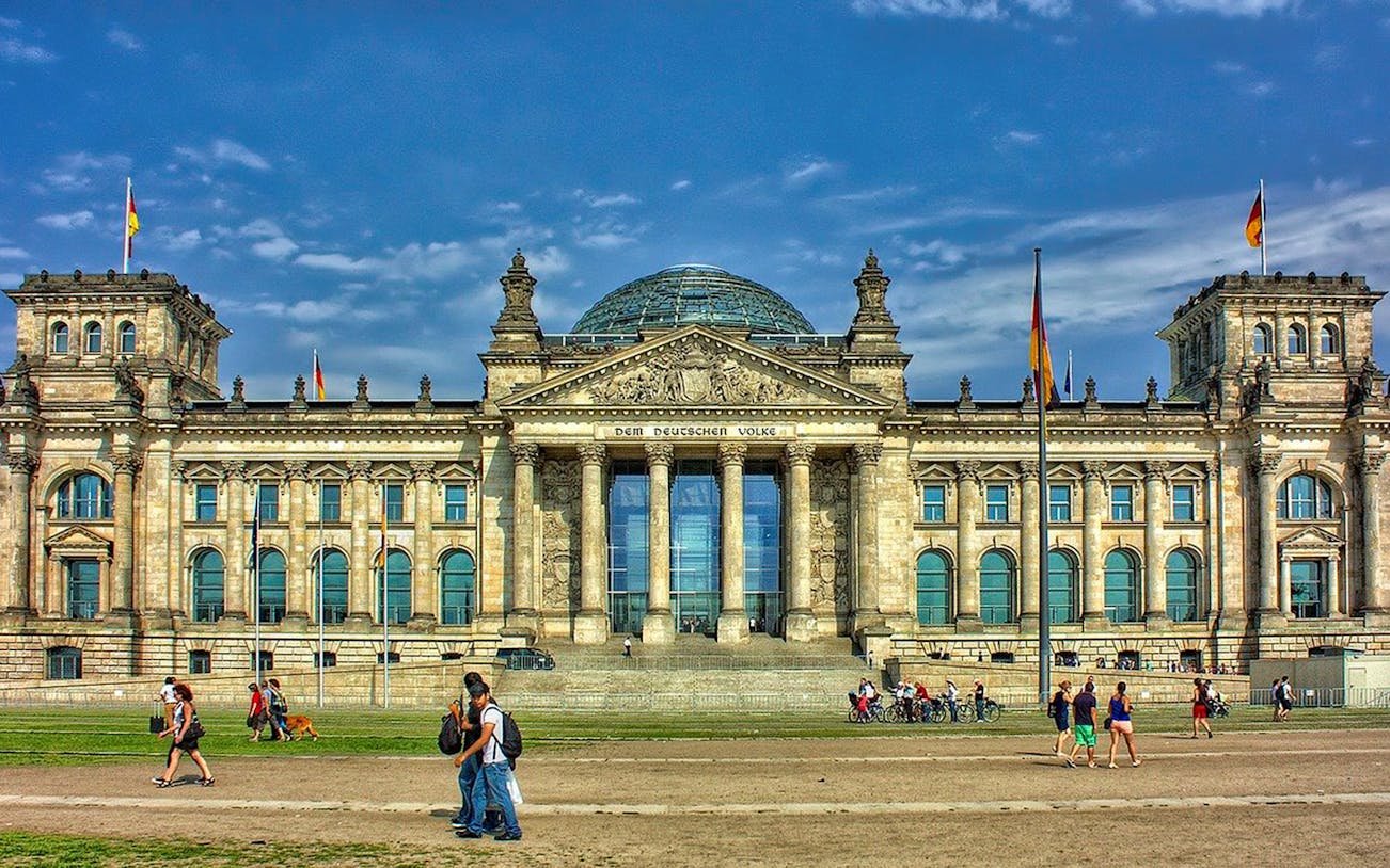 Reichstag building in Berlin with visitors walking in front, part of Berlin EasyCityPass tour.