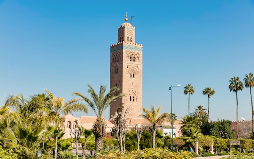 Koutoubia Mosque tower surrounded by palm trees in Marrakesh.