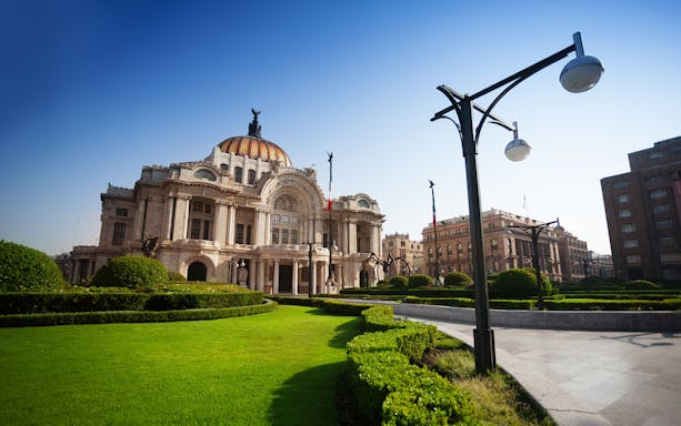 Palacio de Bellas Artes in Mexico City with surrounding gardens.