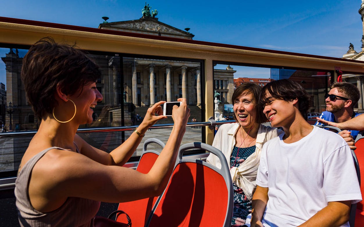 Tourists enjoying a view from a Big Bus Berlin tour with the Konzerthaus Berlin in the background.