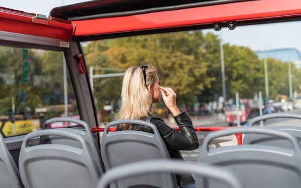 Hop-on hop-off bus passenger with headphones in Berlin, Germany.