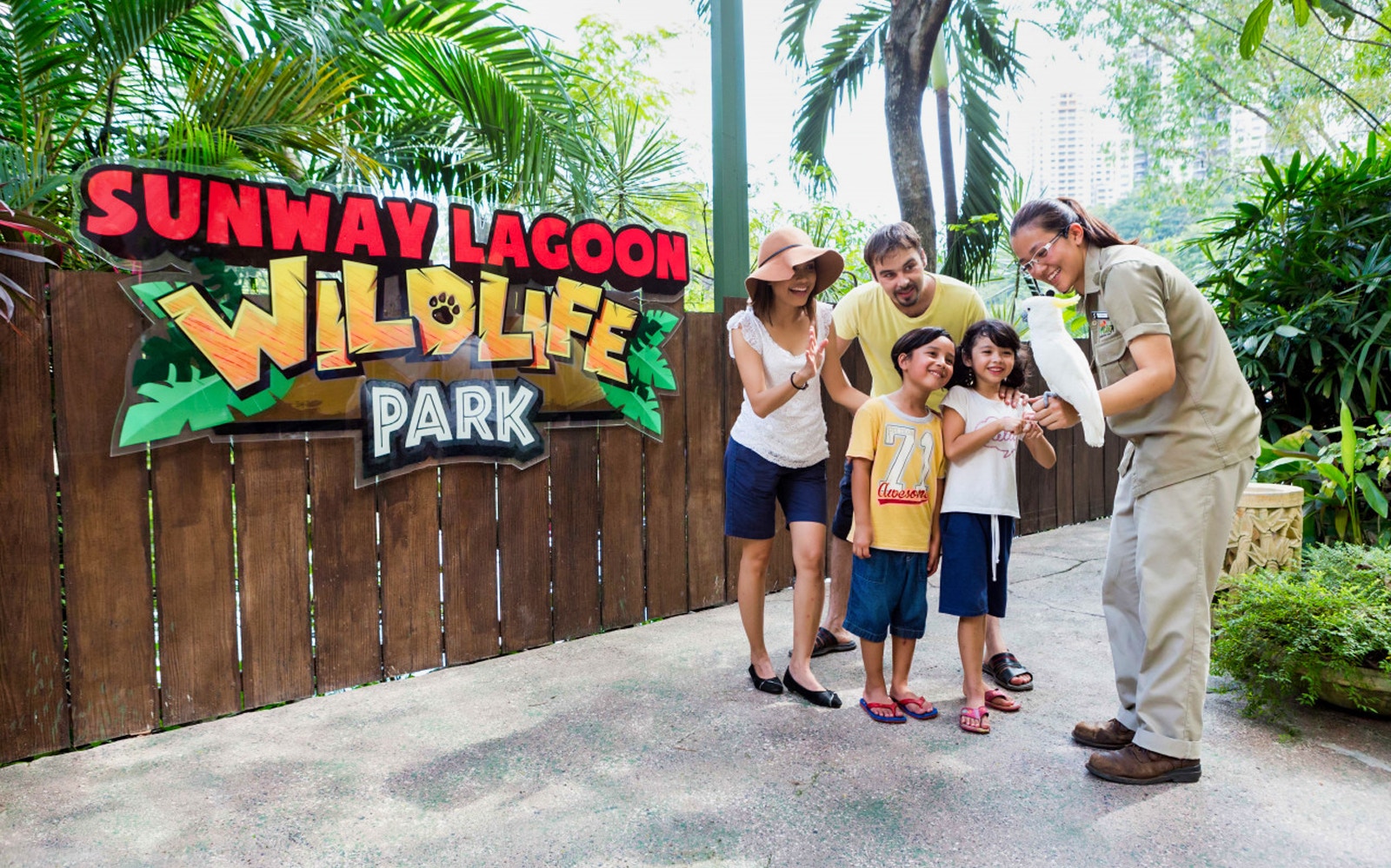 Family interacting with a bird at Sunway Lagoon Wildlife Park, Malaysia.
