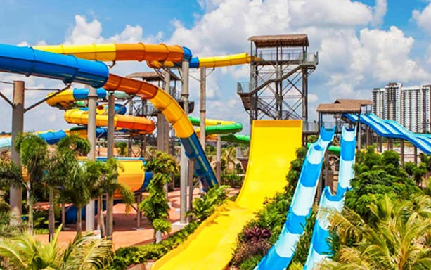 Colorful water slides at Austin Heights Water and Adventure Park with city skyline in the background.