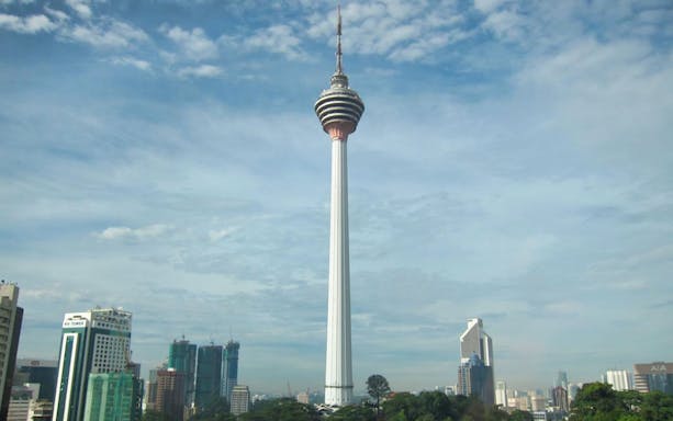 KL Tower in Kuala Lumpur skyline with surrounding buildings.
