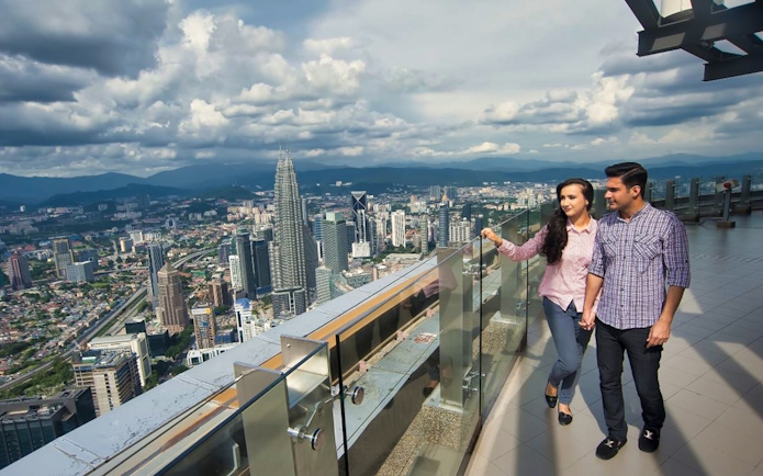 Couple enjoying city view from KL Tower observation deck, Kuala Lumpur.