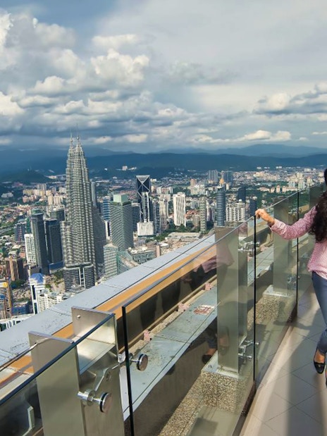 Couple enjoying city view from KL Tower observation deck, Kuala Lumpur.