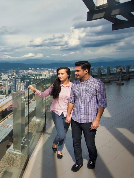 Couple enjoying city view from KL Tower observation deck, Kuala Lumpur.