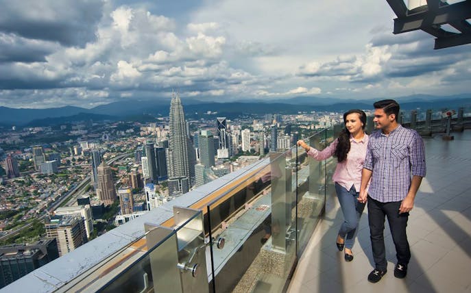Couple enjoying city view from KL Tower observation deck, Kuala Lumpur.