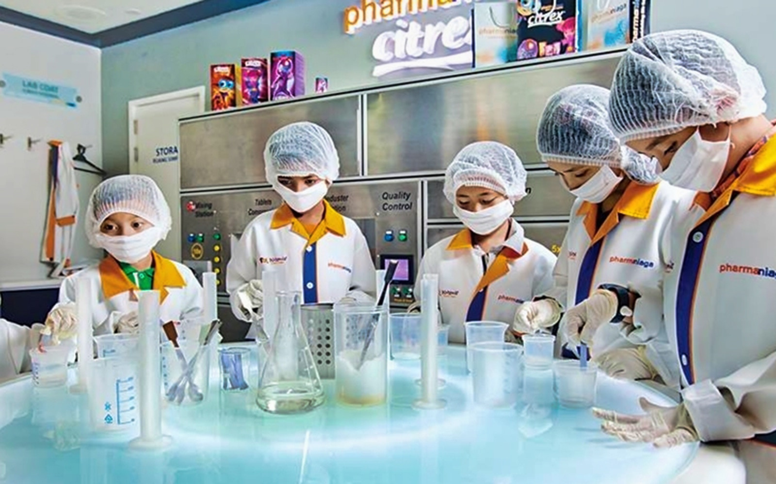 Children in lab coats conducting experiments at Kidzania Malaysia.