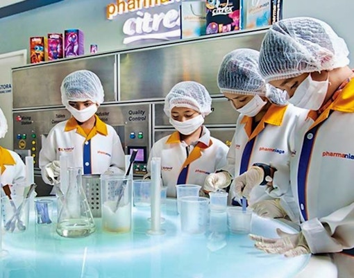 Children in lab coats conducting experiments at Kidzania Malaysia.