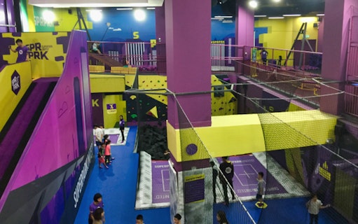 Indoor activity area with trampolines and climbing walls at SuperPark Kuala Lumpur.