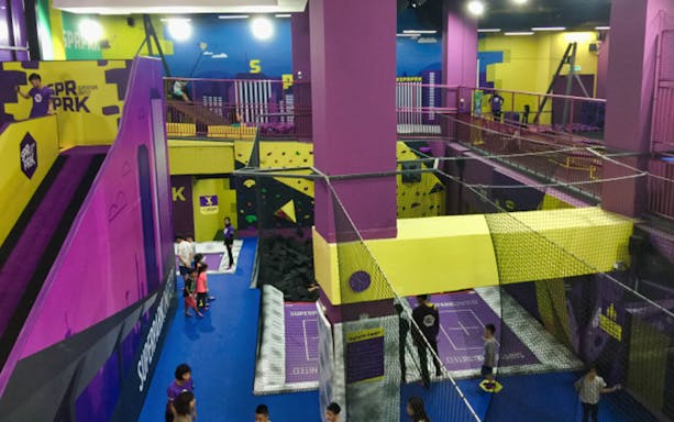 Indoor activity area with trampolines and climbing walls at SuperPark Kuala Lumpur.