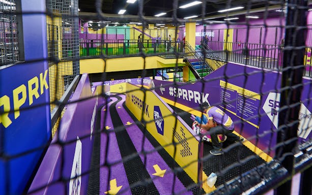 Indoor tube slide at SuperPark Kuala Lumpur with vibrant purple and yellow design.