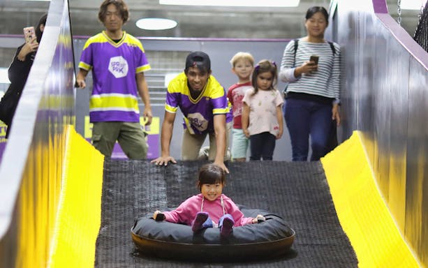 Child sliding down a ramp in an inflatable tube at SuperPark Kuala Lumpur.