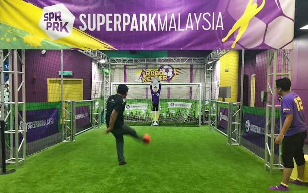 Man playing soccer game at SuperPark Kuala Lumpur indoor activity center.