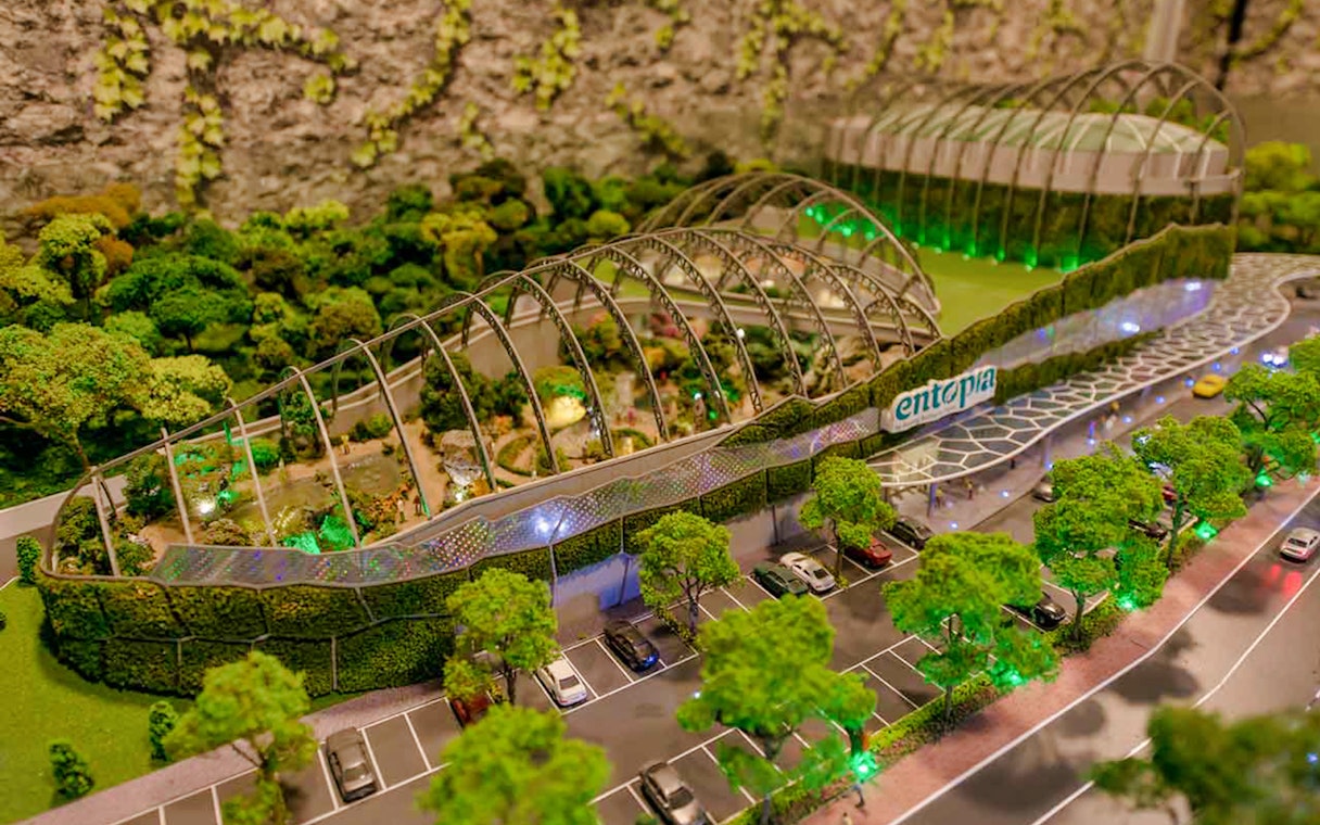 Entopia Penang Butterfly Farm entrance with lush greenery and parking area.