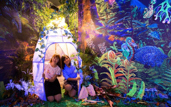 Visitors exploring glowing art installations at Dark Mansion Museum.