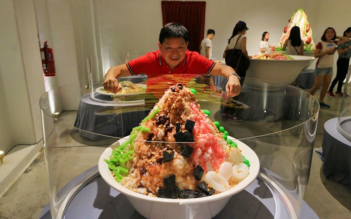 Man admiring large dessert display at Wonderfood Museum.