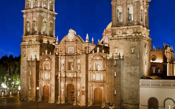 Puebla Cathedral illuminated at night, featured on the Puebla & Cholula Day Tour from Mexico City.