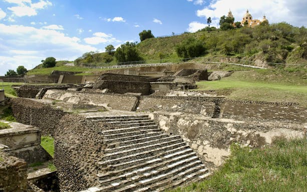 Ancient pyramid ruins in Cholula with a church on the hill, Puebla, Mexico.