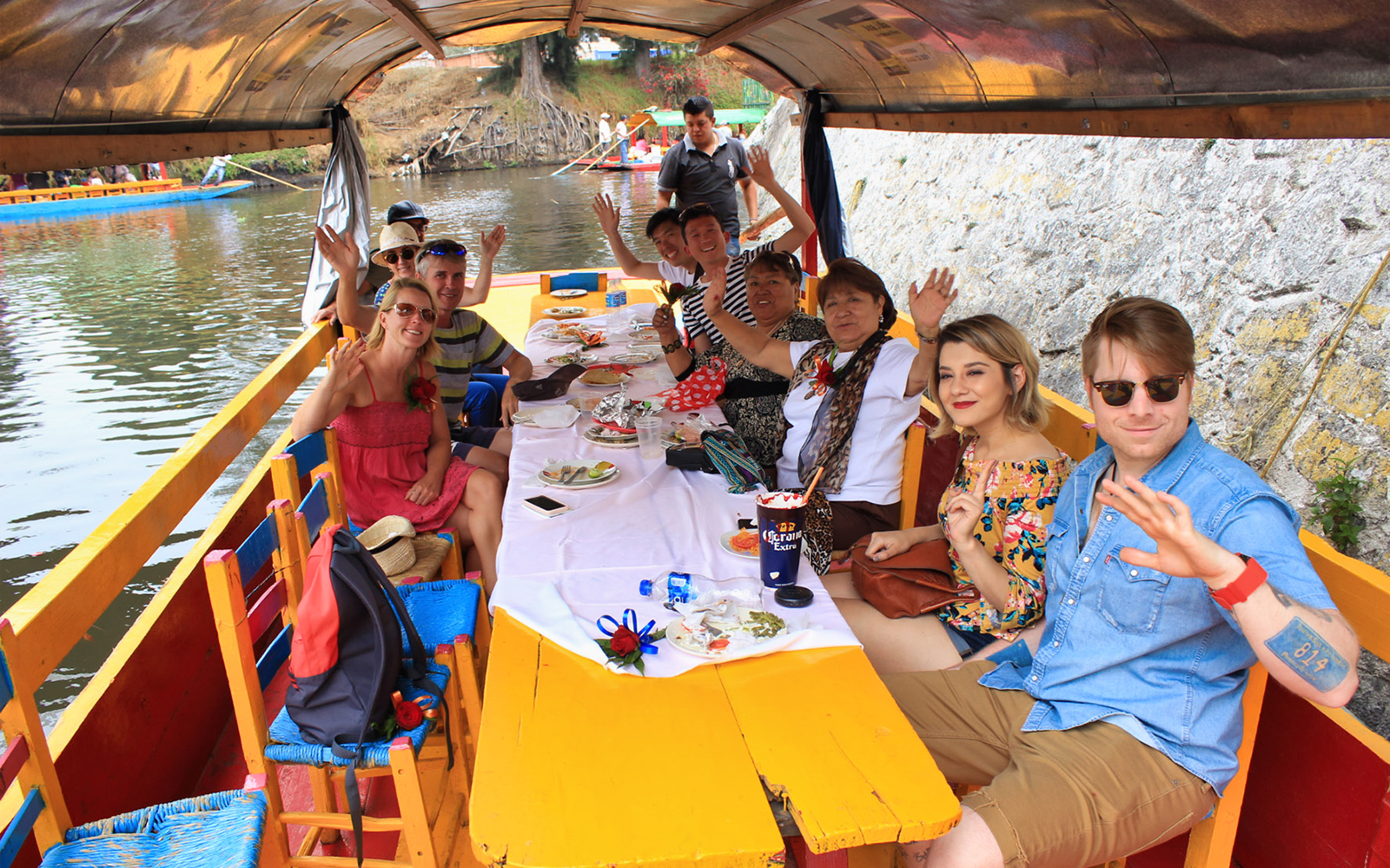 Tourists enjoying a boat ride in Xochimilco, Mexico City, with colorful decorations.