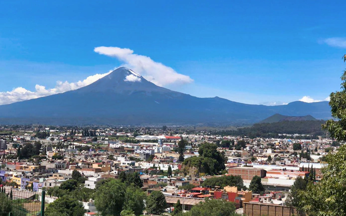 Puebla cityscape with Popocatépetl volcano in the background, seen on a day tour from Mexico City.