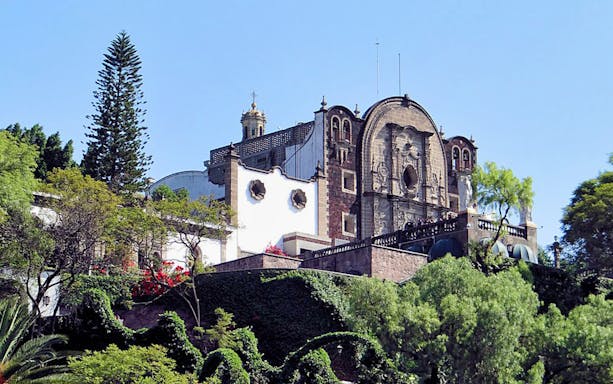 Guadalupe Basílica exterior with surrounding greenery in Mexico City.