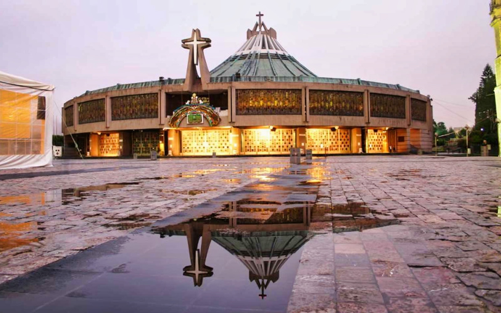 Guadalupe Basilica exterior with reflection on wet plaza, Mexico City.