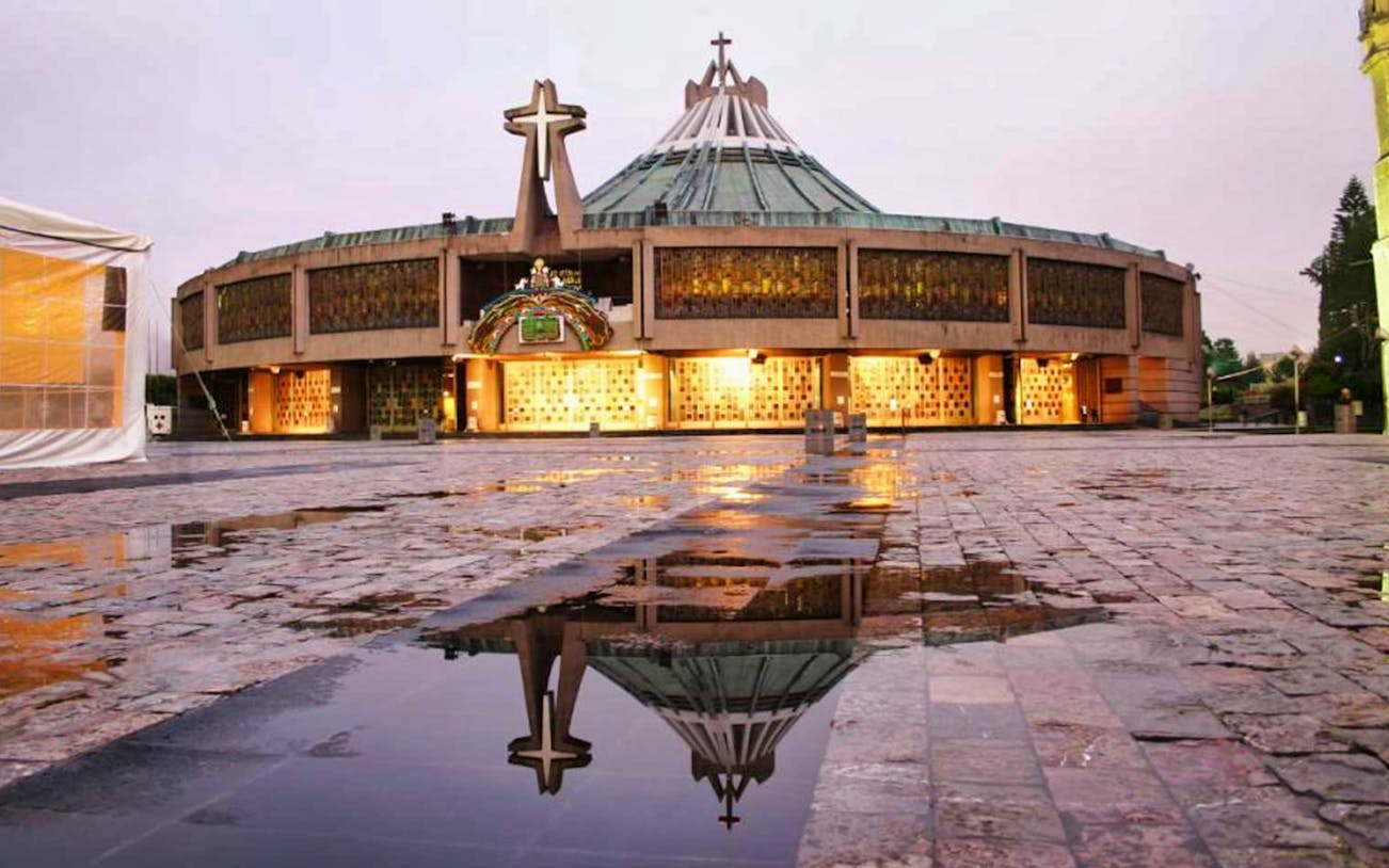 Guadalupe Basilica exterior with reflection on wet plaza, Mexico City.