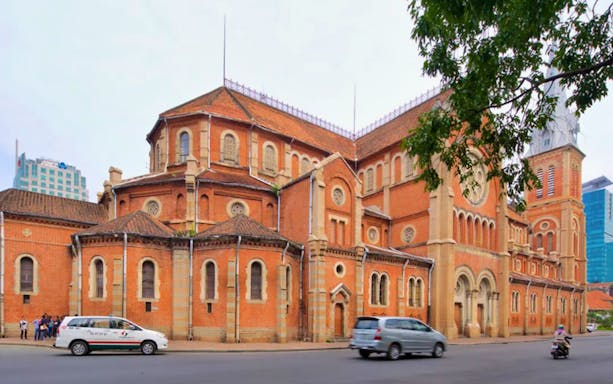 Notre-Dame Cathedral Basilica in Ho Chi Minh City, Vietnam, with passing vehicles.