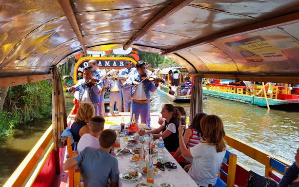 Mariachi band performing on a colorful boat in Xochimilco, Mexico City tour.