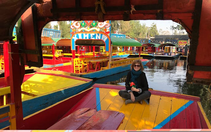 Colorful trajineras on Xochimilco canals during Mexico City half-day guided tour.
