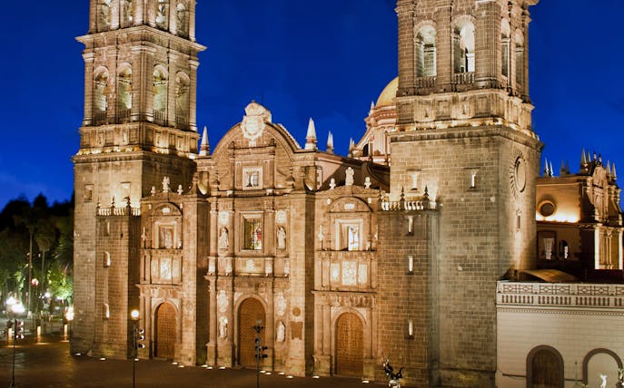 Mexico City Metropolitan Cathedral illuminated at night during a guided tour.