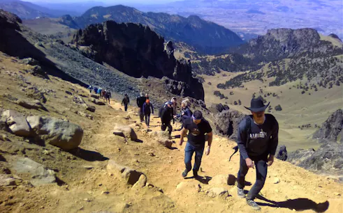Hikers ascending a rocky trail in Iztaccíhuatl-Popocatépetl National Park.