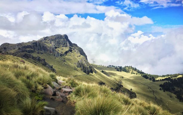 Hiking trail through grassy slopes in Iztaccíhuatl-Popocatépetl National Park.