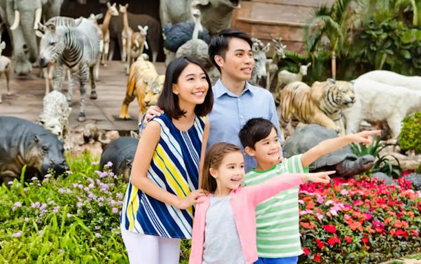 Family enjoying Noah's Ark with animal sculptures in the background.