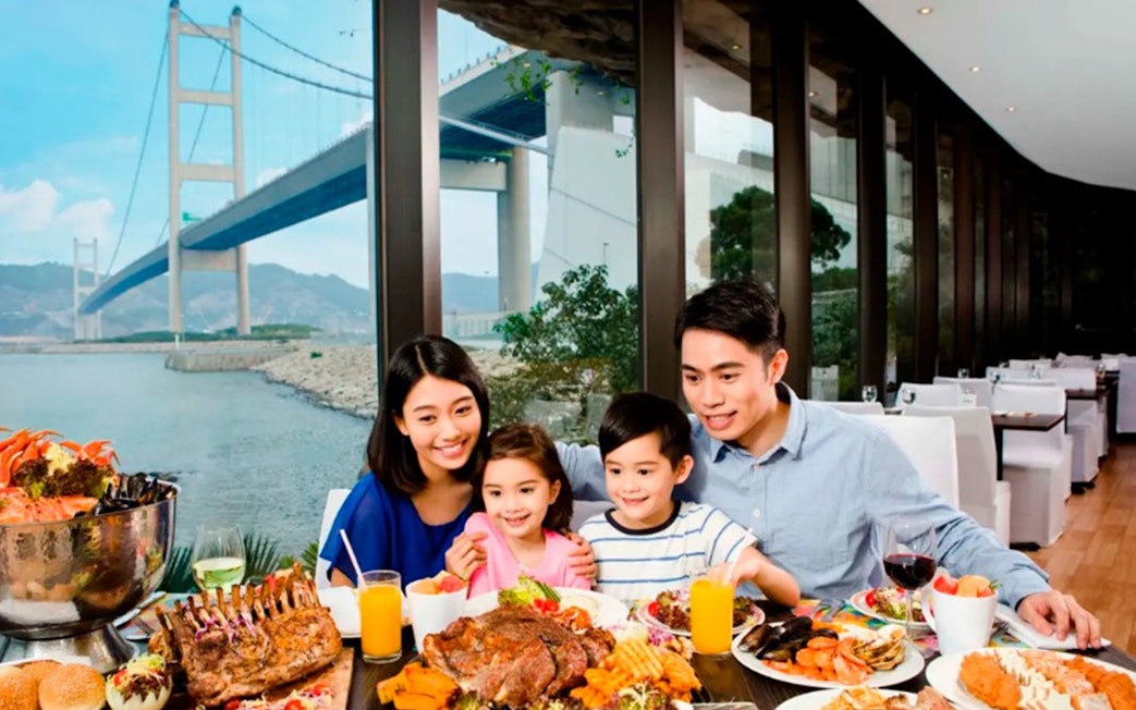 Family dining with Tsing Ma Bridge view at Noah's Ark, Hong Kong.