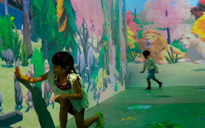 Children interacting with animal projections at Noah's Ark exhibit.